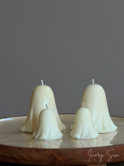 White colour soy wax ghost-shaped halloween candles displayed on a tray against a neutral grey background. Soy Halloween candles handmade by Ivory Sun.
