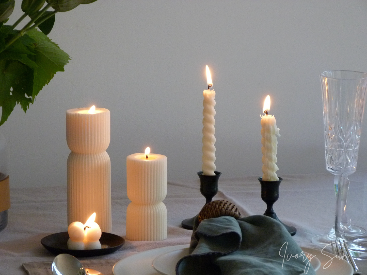 Candlelit table setting with various candles and a glass on a white surface.
metal candle holders, black candle holders, black candle holders, candle holders australia, candle holder, candle holder australia, ivory sun candle holder, candle accessories, wedding candle holders, dinner party candle holders, decor candle holders, twin candle holders, table decor, taper candles, candle holders set