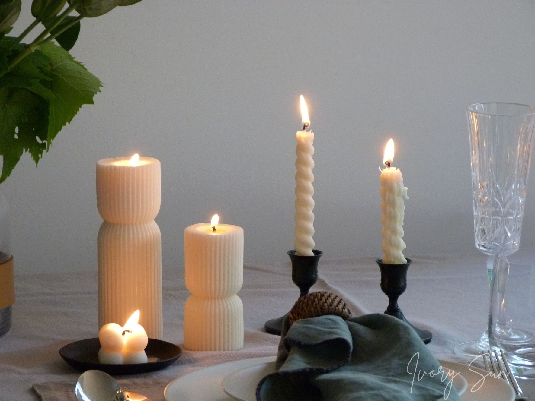 Candlelit table setting with various candles and a glass on a white surface.
metal candle holders, black candle holders, black candle holders, candle holders australia, candle holder, candle holder australia, ivory sun candle holder, candle accessories, wedding candle holders, dinner party candle holders, decor candle holders, twin candle holders, table decor, taper candles, candle holders set