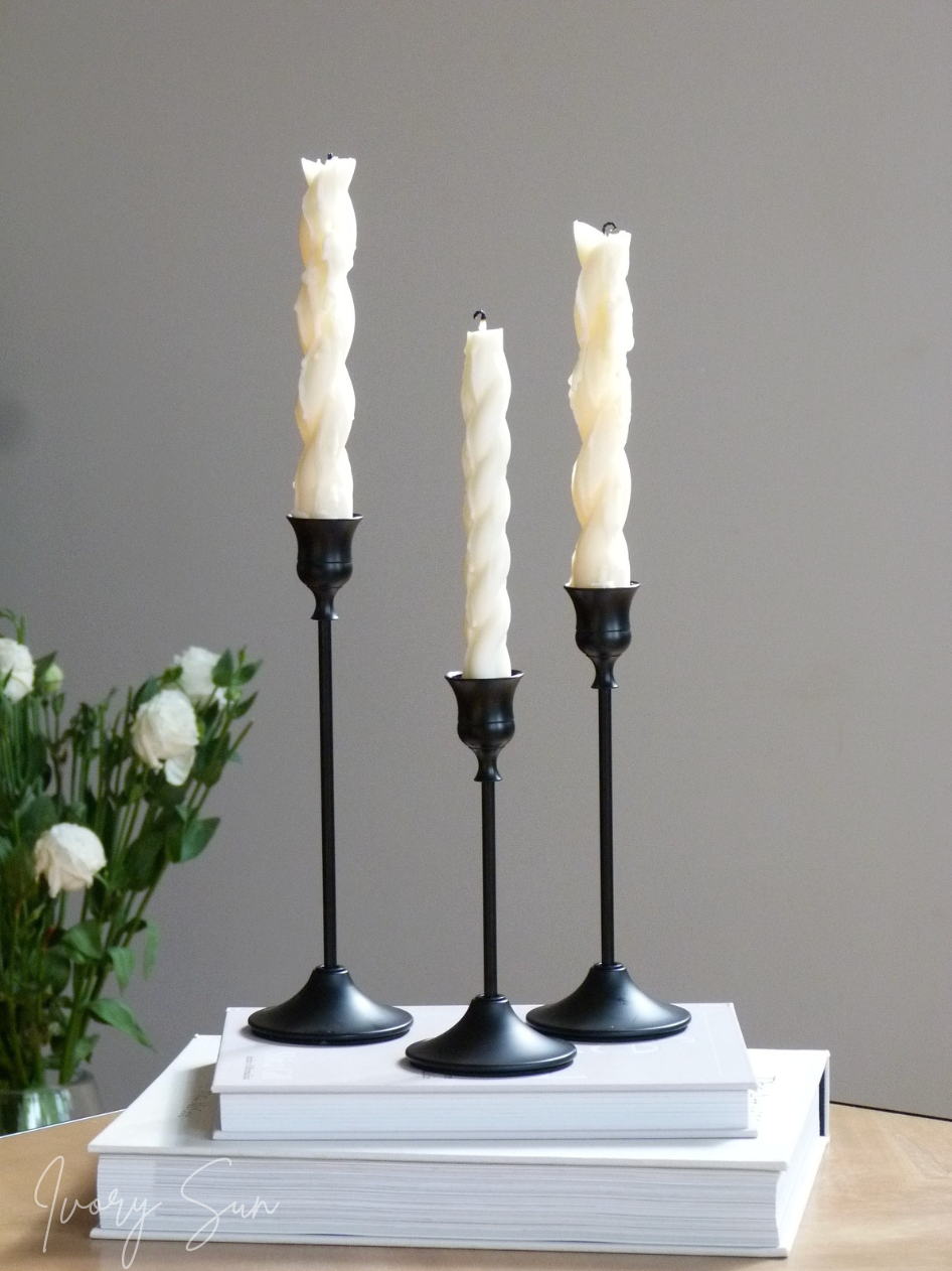 Three candlesticks with white candles on a stack of books against a gray background.
metal candle holders, black candle holders, black candle holders, candle holders australia, candle holder, candle holder australia, ivory sun candle holder, candle accessories, wedding candle holders, dinner party candle holders, decor candle holders, twin candle holders, table decor, taper candles, candle holders set