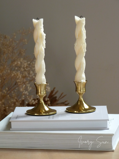 Two white twisted taper candles on gold candle holders with a blurred background.
metal candle holders, gold candle holders, golden candle holders, candle holders australia, candle holder, candle holder australia, ivory sun candle holder, candle accessories, wedding candle holders, dinner party candle holders, decor candle holders, twin candle holders, table decor, taper candles