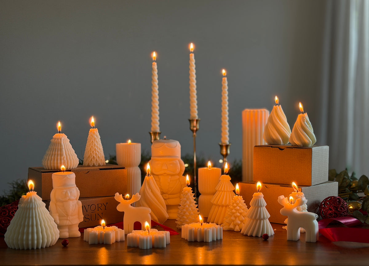 Handmade sculptural Christmas candles by Ivory Sun, featuring elegant Christmas tree, nutcracker, reindeer and snowflake designs, lit and beautifully styled on a wooden table.