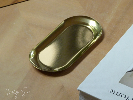 Gold oval tray on a wooden surface with a white book in the background.
metal candle tray, gold candle tray, golden candle tray, golden candle plate, oval candle tray, candle tray australia, candle holder, candle holder australia, ivory sun candle holder, candle accessories