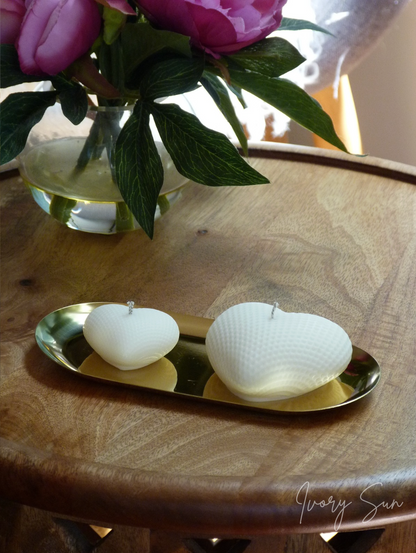 Two white heart shaped textured candles on a gold tray with a vase of purple flowers in the background.
Gold oval tray on a wooden surface.
metal candle tray, gold candle tray, golden candle tray, golden candle plate, oval candle tray, candle tray australia, candle holder, candle holder australia, ivory sun candle holder, candle accessories