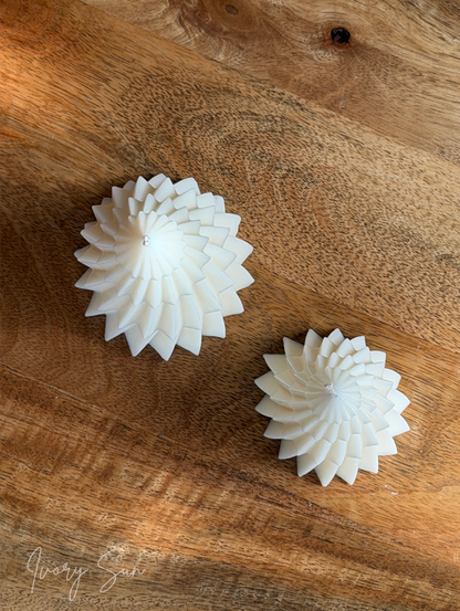 Two white spiral shaped Christmas Tree candles with layered edges, displayed on a rustic brown wooden surface. Handmade Christmas candles by Ivory Sun, beautifully presented as a Christmas gift set. Discover Christmas gift ideas and Christmas Candles in Australia.