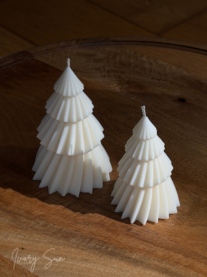 Two white soy Christmas tree shaped layered candles on a rustic wooden surface, with one large candle and one small candle. Handmade Christmas candles by Ivory Sun, beautifully presented as a Christmas gift set. Discover Christmas gift ideas and Christmas Candles in Australia.